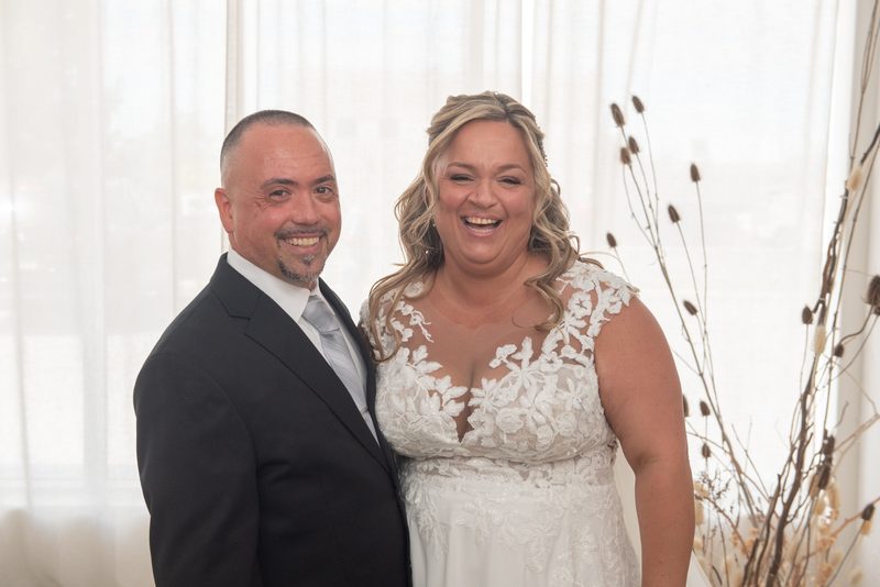 Candace and Felice smile broadly at the camera, their happiness evident in the candid moment captured during their wedding.