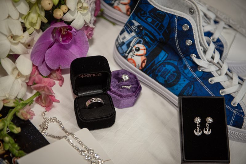 Jewelry and Star Wars sneakers sit with orchids in a soft, natural light setup, celebrating a milestone.