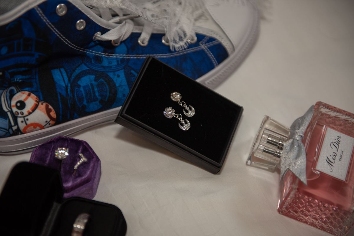 A blue Star Wars BB-8 sneaker, perfume bottle, jewelry box, and ring case arranged on a white backdrop.