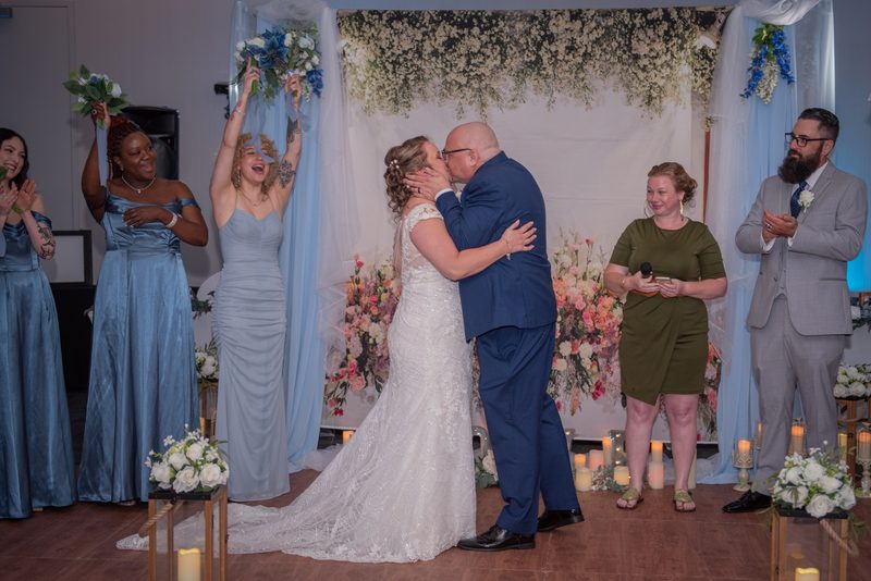 Jennifer and Joe share an intimate kiss at their wedding ceremony, surrounded by joyful guests in Vaughan.