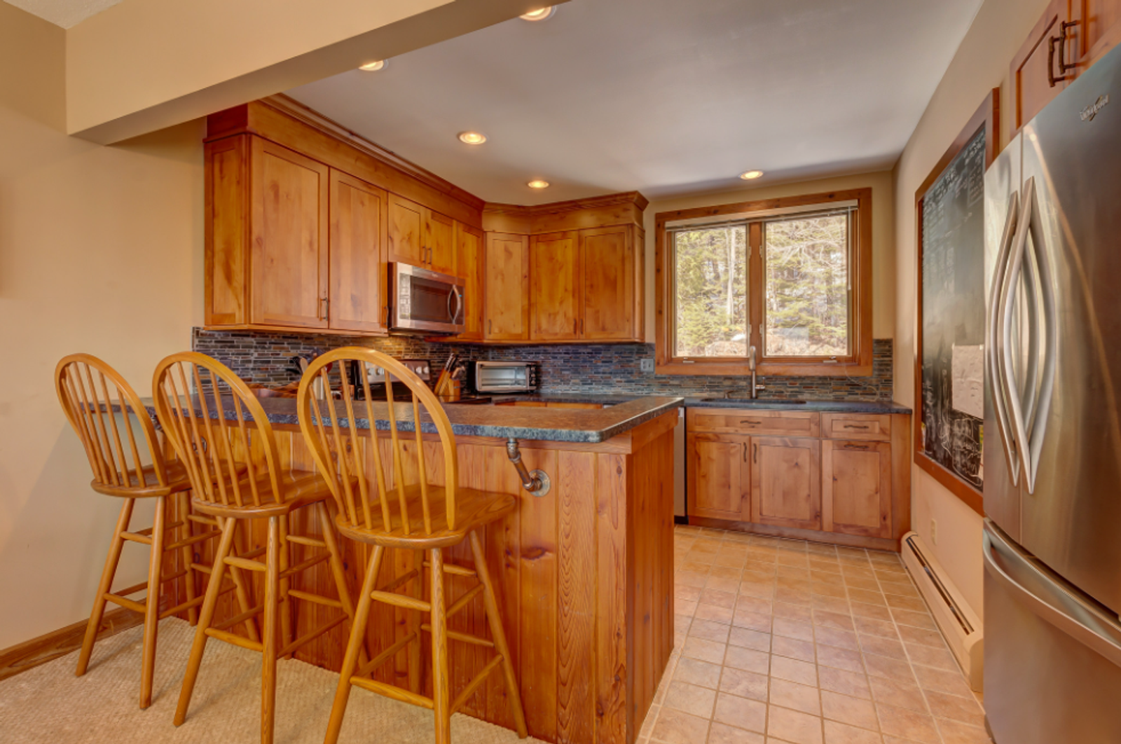 Kitchen remodel with rustic stone finish cabinets Bromley Village Vermont by Tradecraft VT
