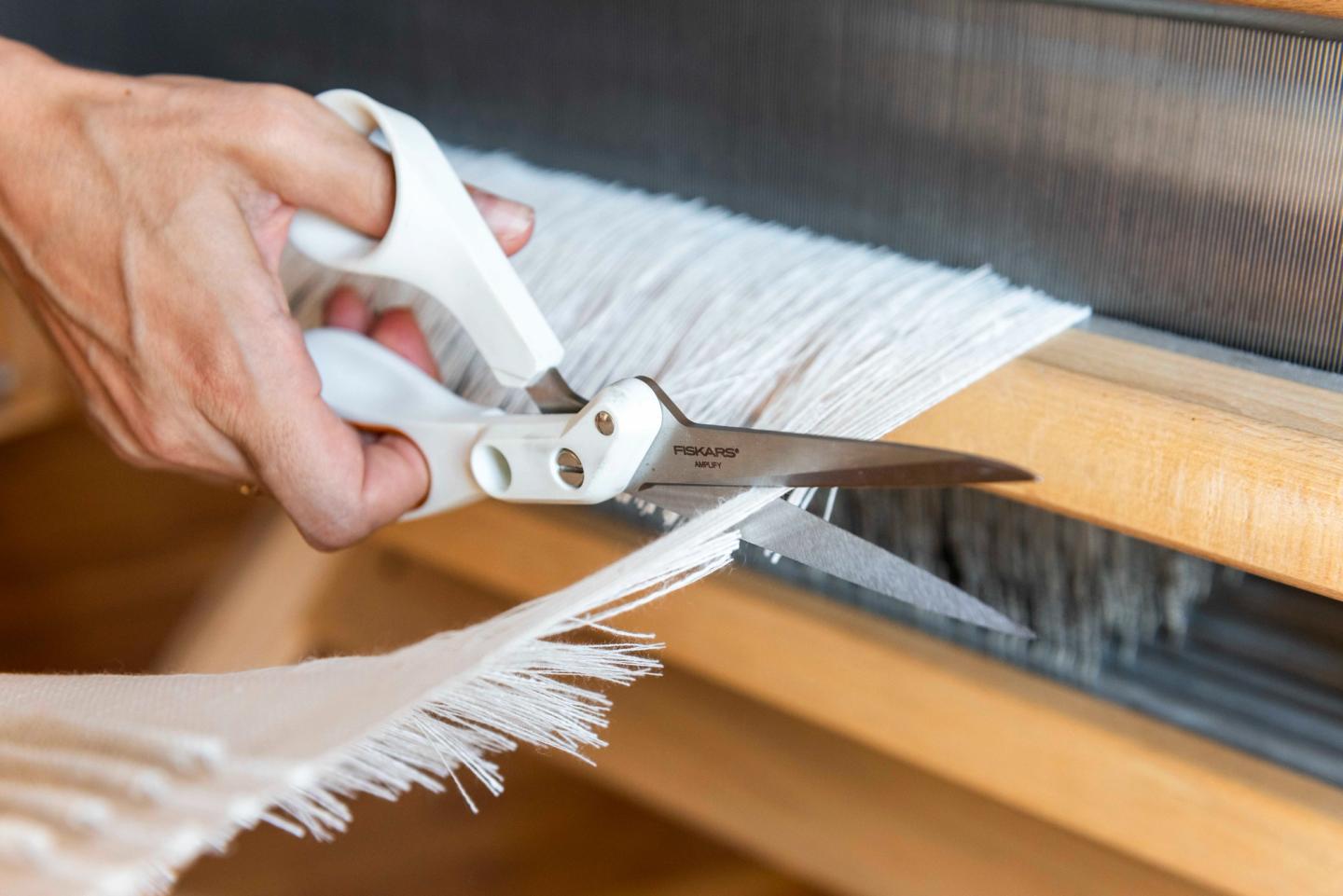 Travail d’un tissage blanc sur le métier à bras