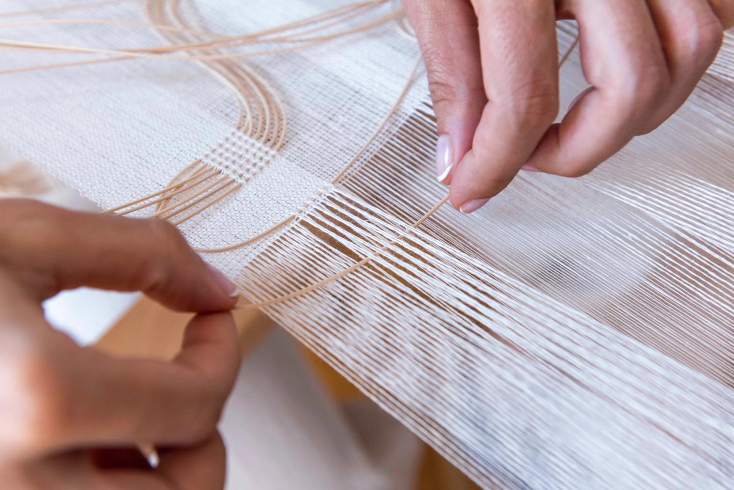 Inserting rattan into the weave by hand