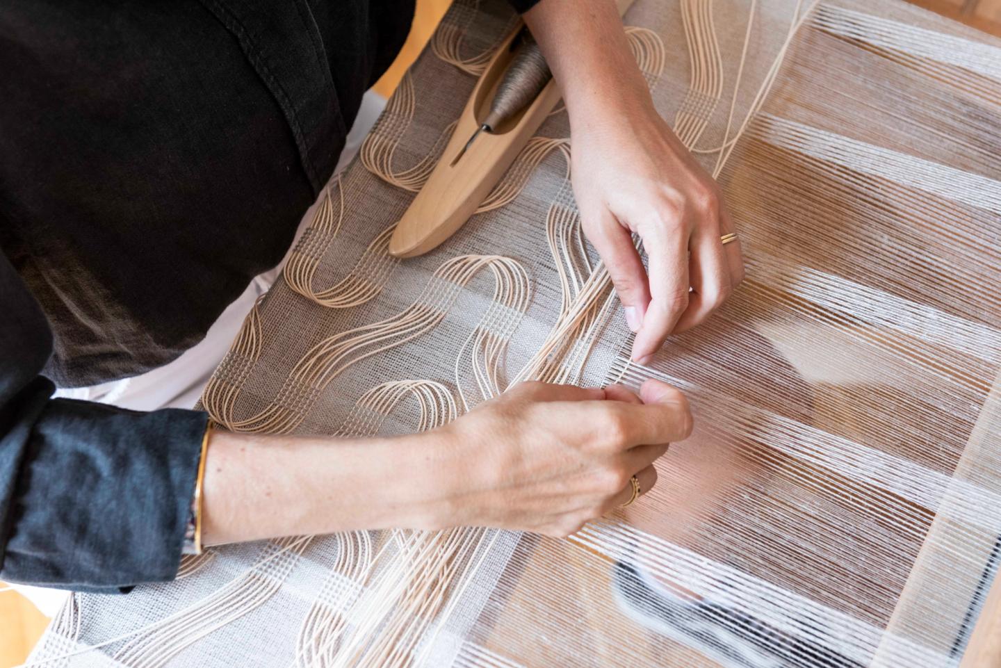 Hands weaving Lin & Rotin on the loom at the Saint Frison studio
