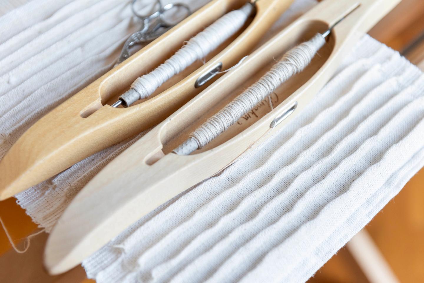 Shuttles on a white pleated weave