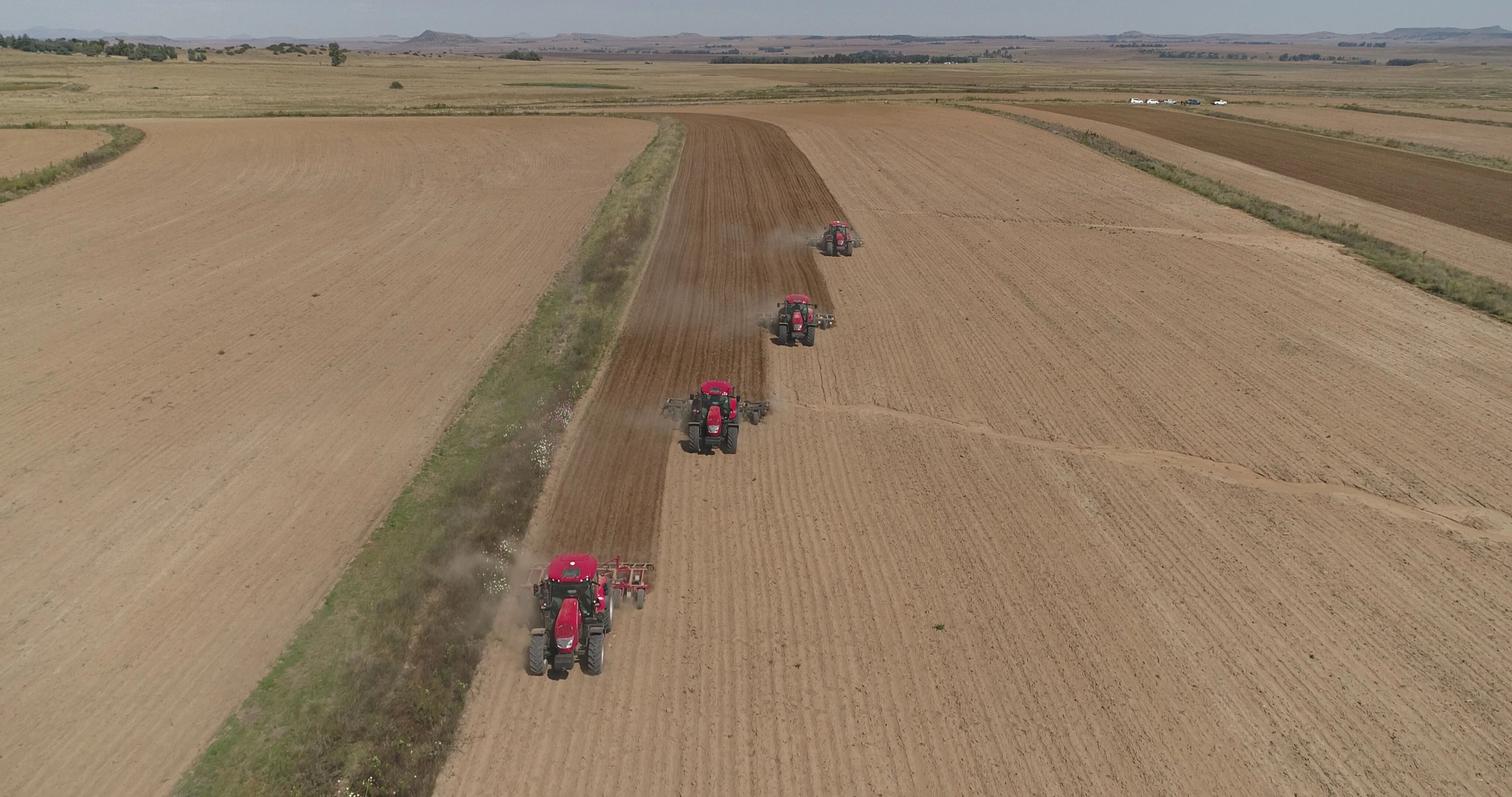 McCormick tractors working in formation across a field