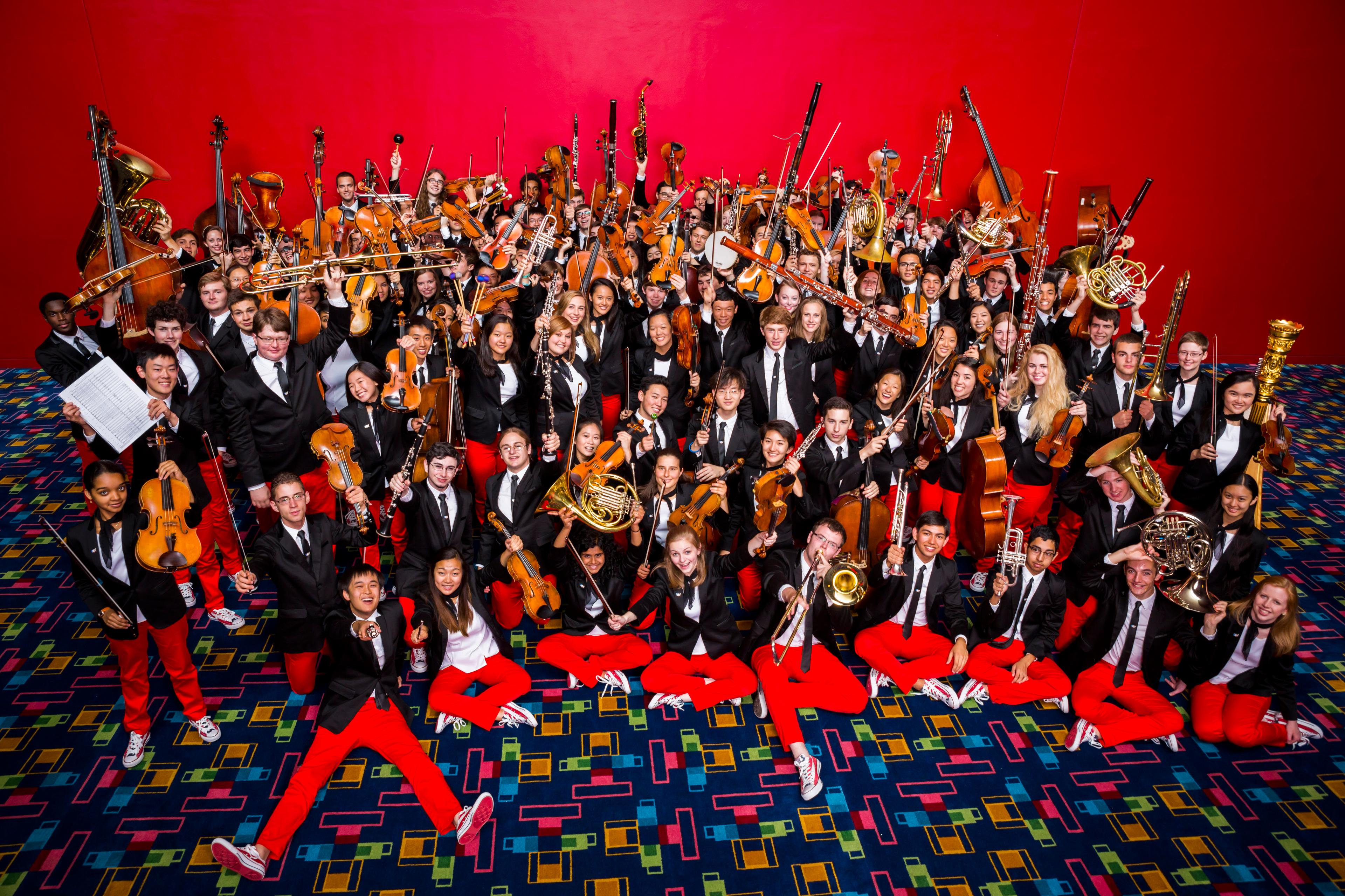 National Youth Orchestra group photo with instruments held in the air 