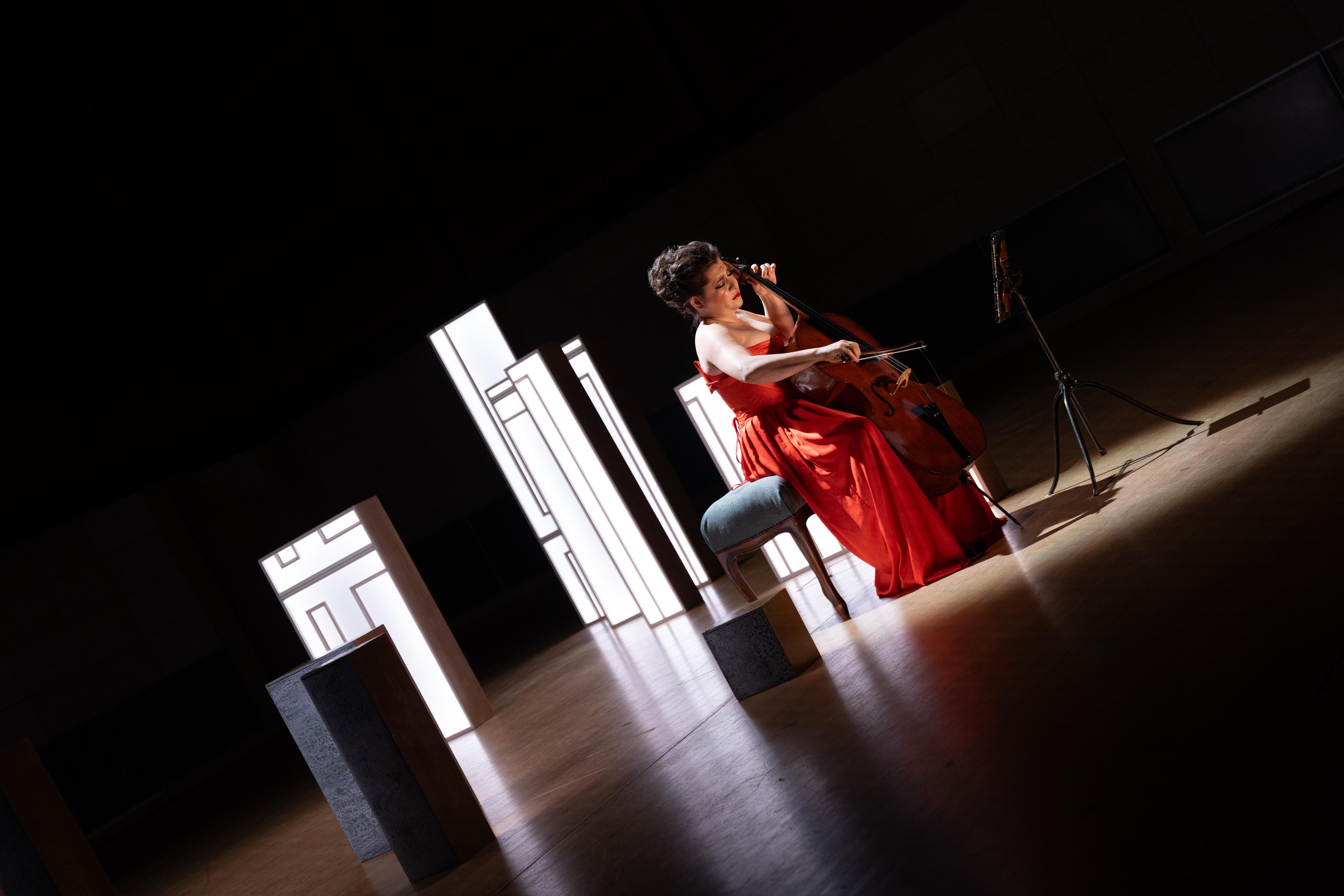 Cellist Alisa Weilerstein performs amongst some scattered light boxes