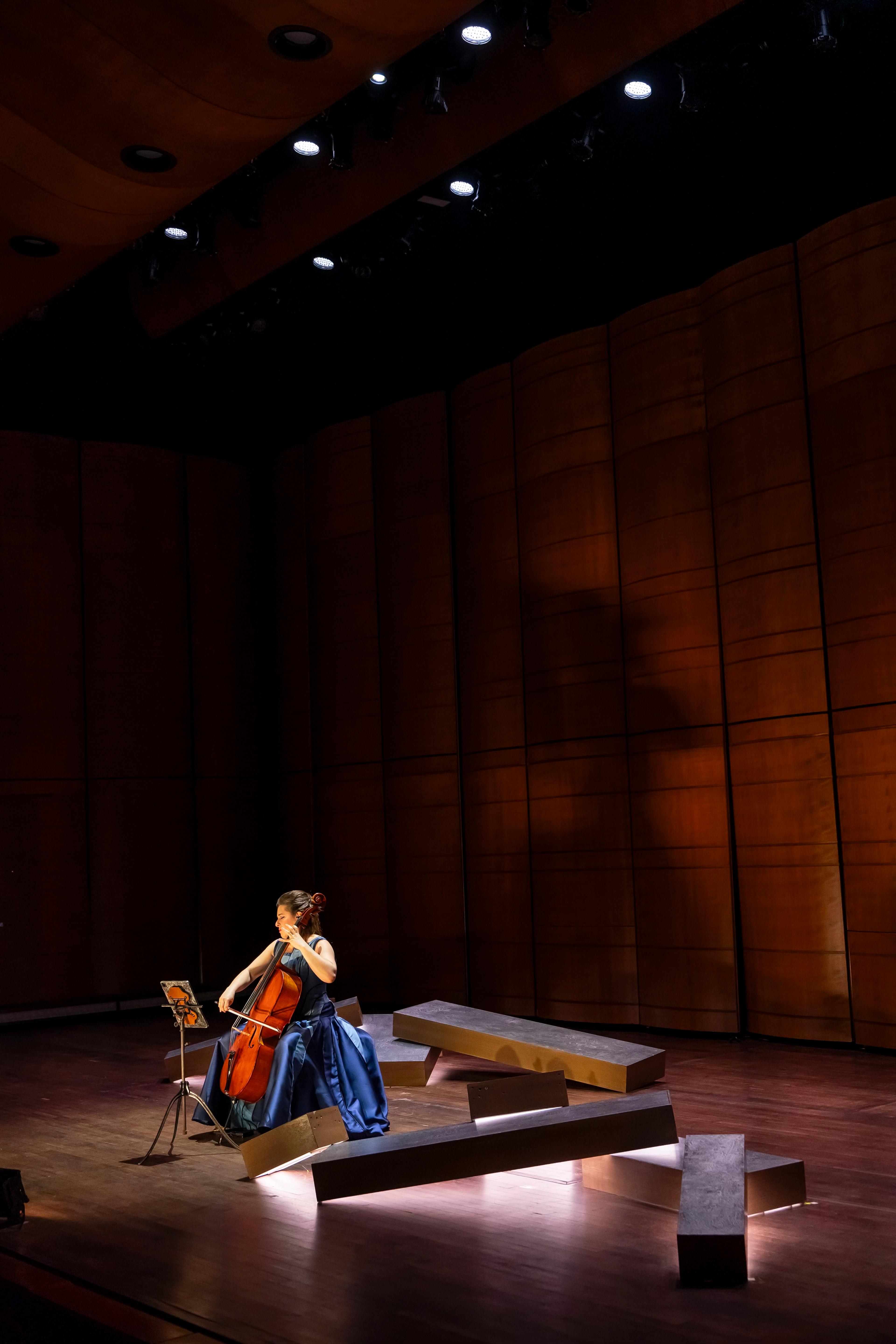 Cellist Alisa Weilerstein performing on top of a pyre of lit boxes