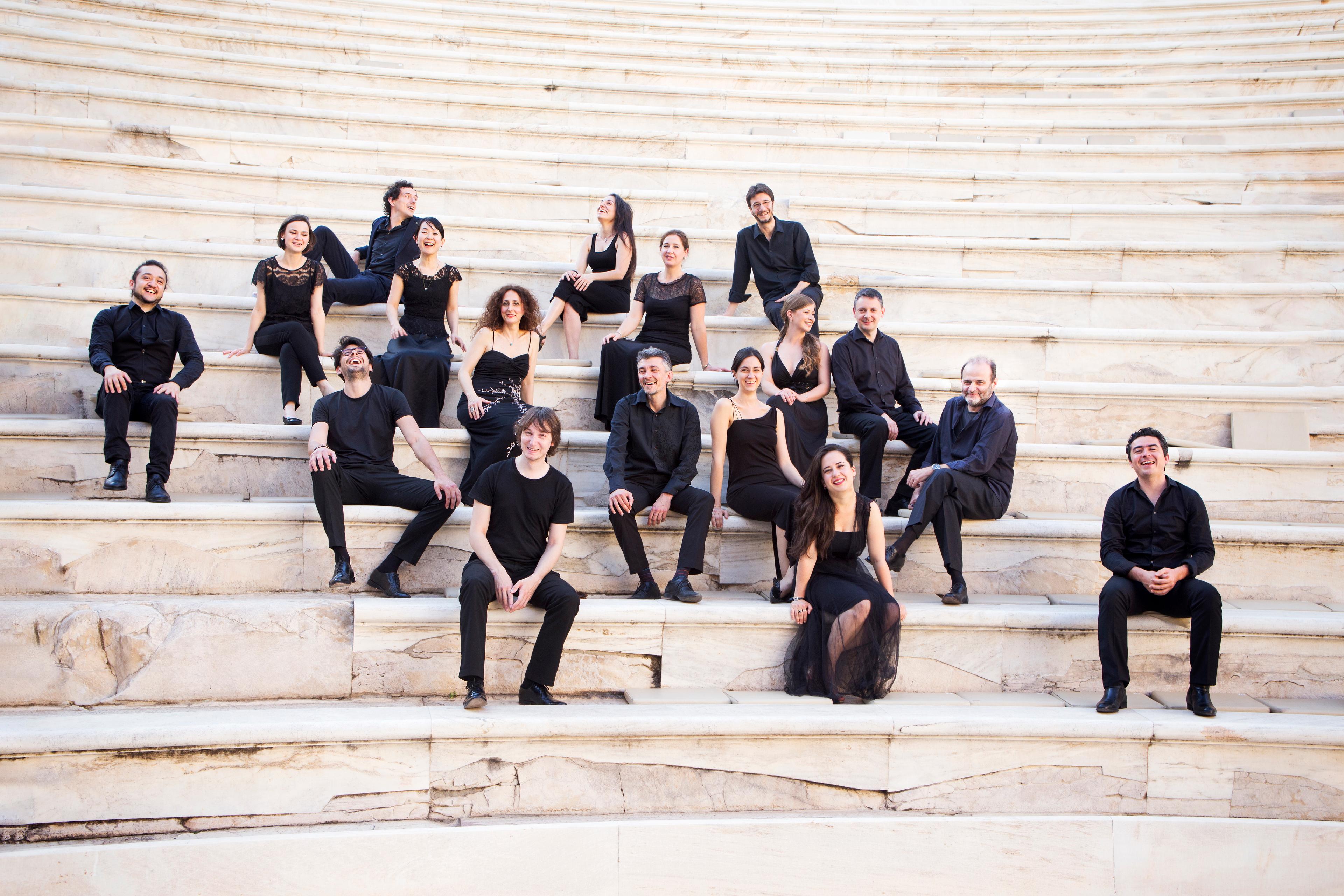 Musicians of the ensemble posing on the stairs on an outdoor Roman theatre