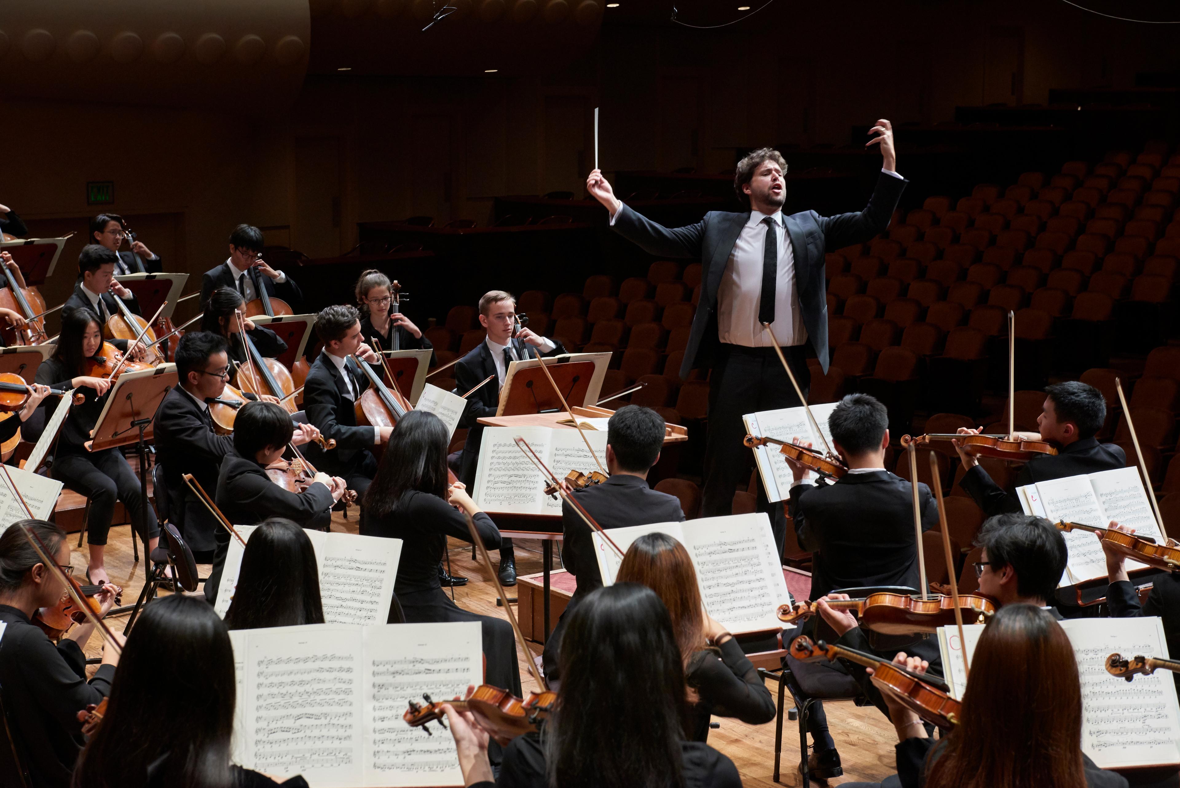 Christian Reif conducting the orchestra on stage