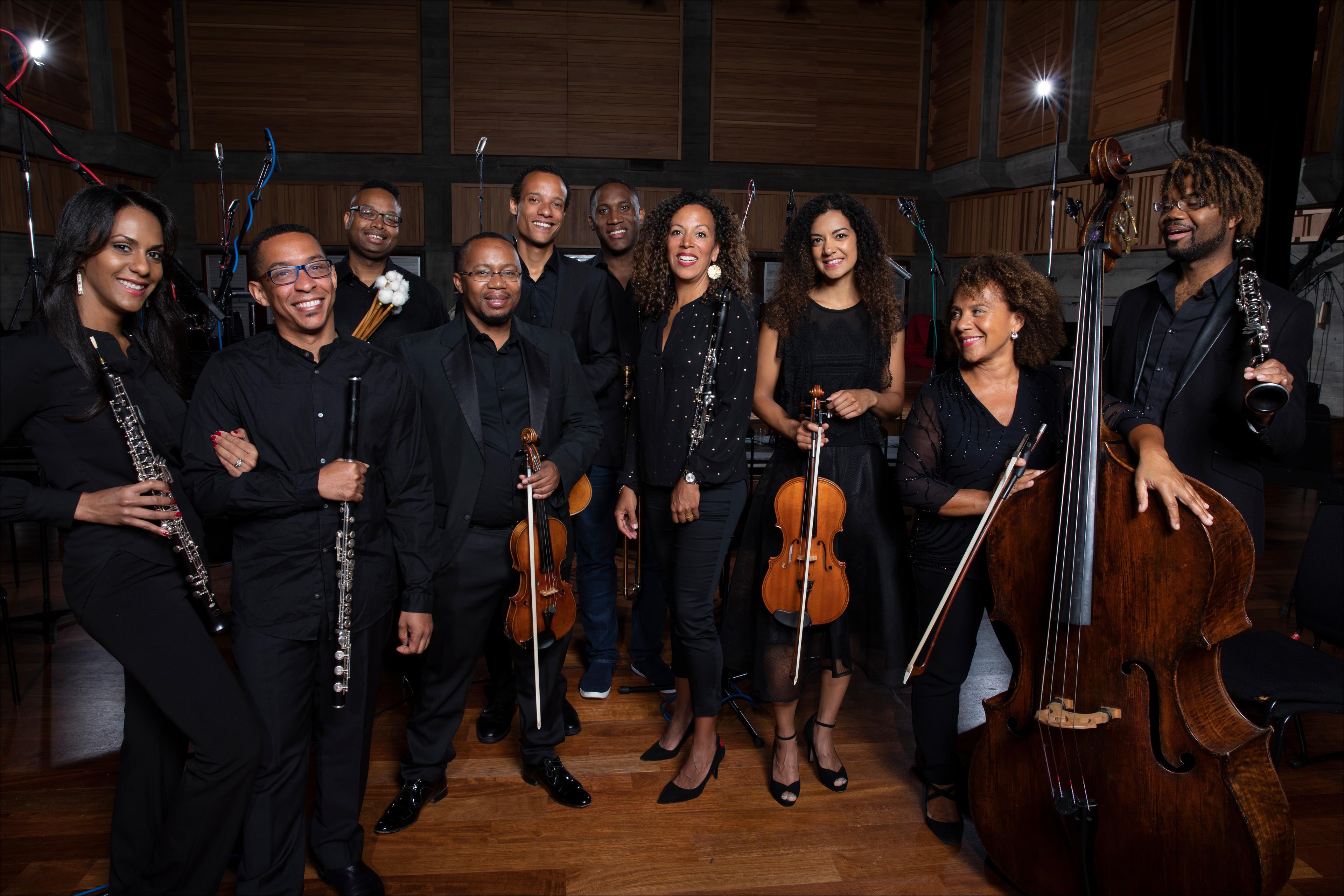 Members of Chineke! Orchestra with their instruments smiling at the camera 