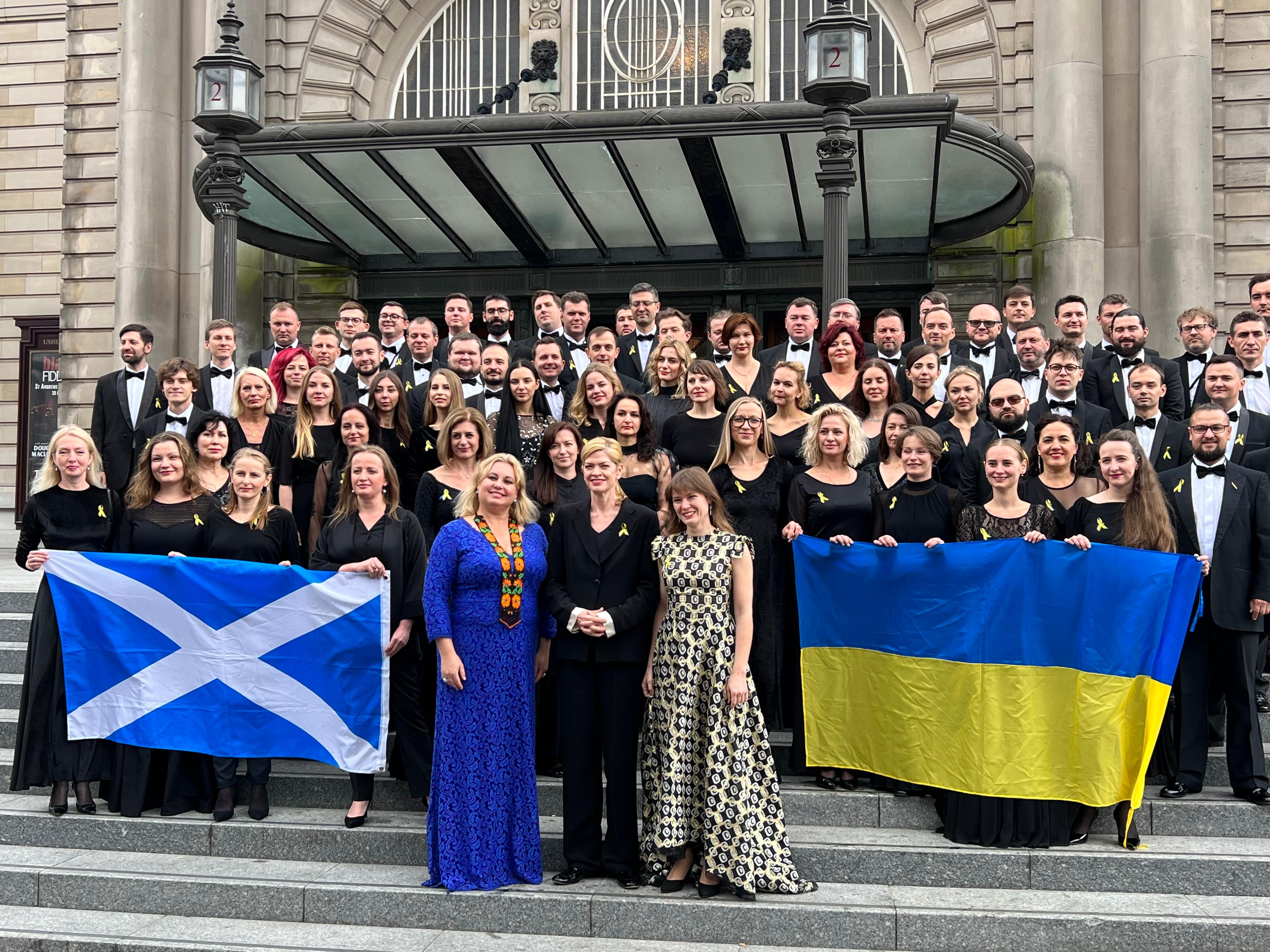 The Ukrainian Freedom Orchestra stood as a group at the Edinburgh International Festival, holding both Scottish and Ukrainian flags