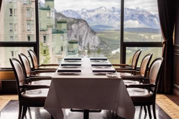 Interior of a dining room over looking a mountain view through the windows,