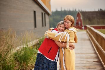Two female heritage site workers smiling and hugging.