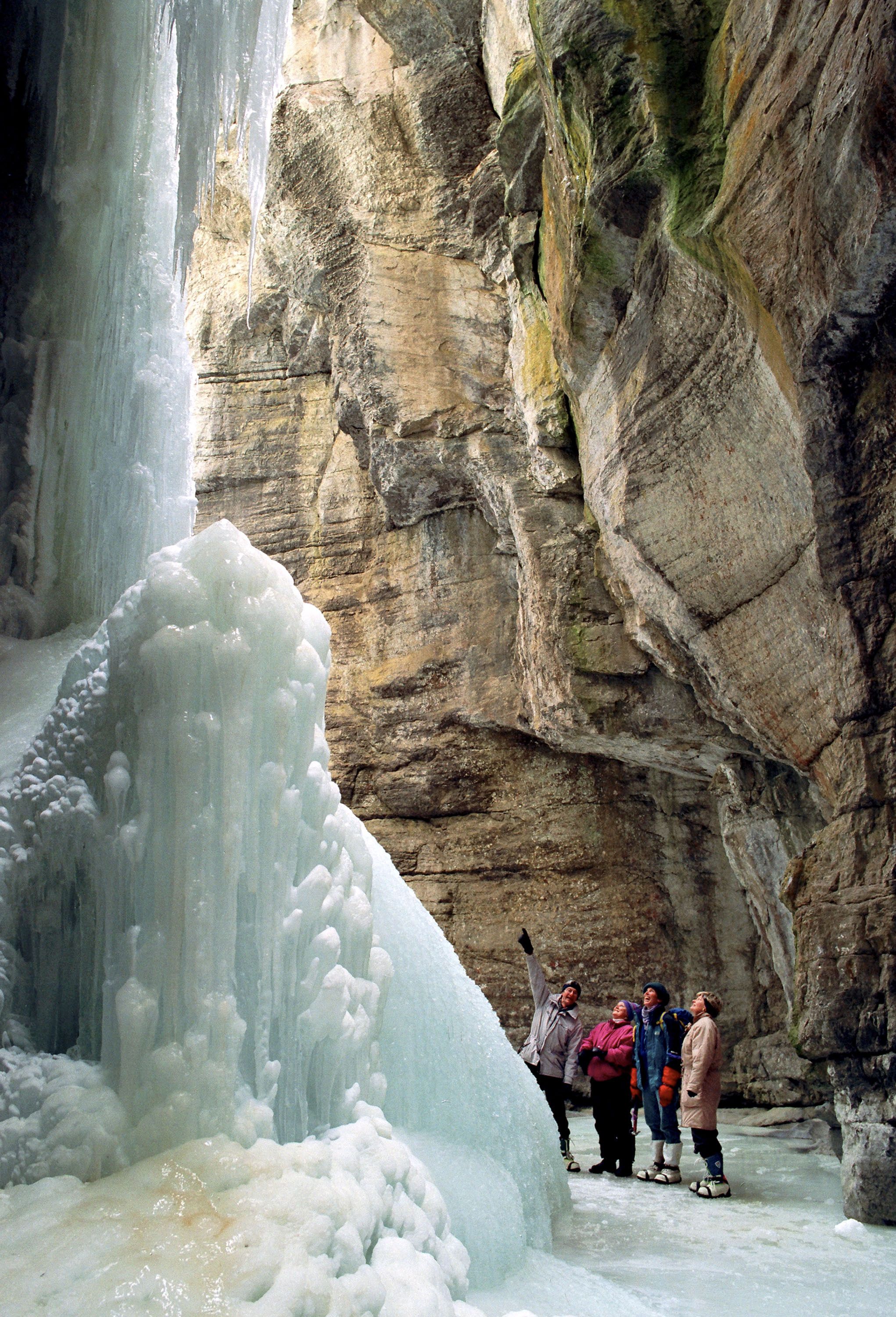 A distant shot of a group of people on a guided ice hiking tour in Maligne Canyon in Jasper National Park
