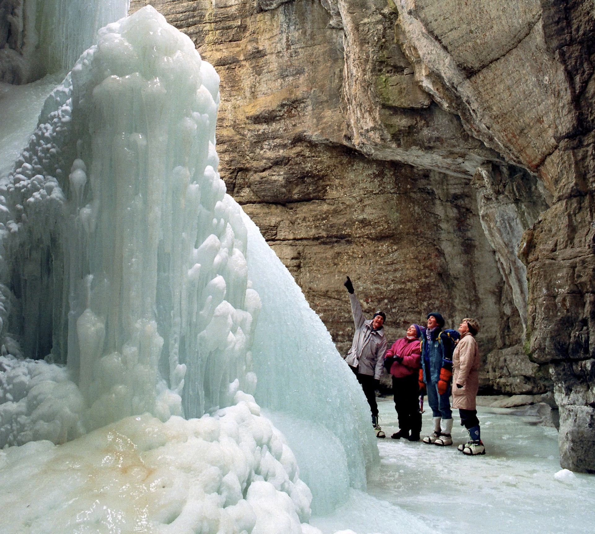 A distant shot of a group of people on a guided ice hiking tour in Maligne Canyon in Jasper National Park