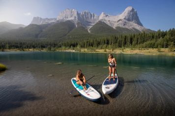 two women stand up paddle boarding quarry lake canmore