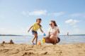 A mom and young daughter play in the sand at Sylvan Lake