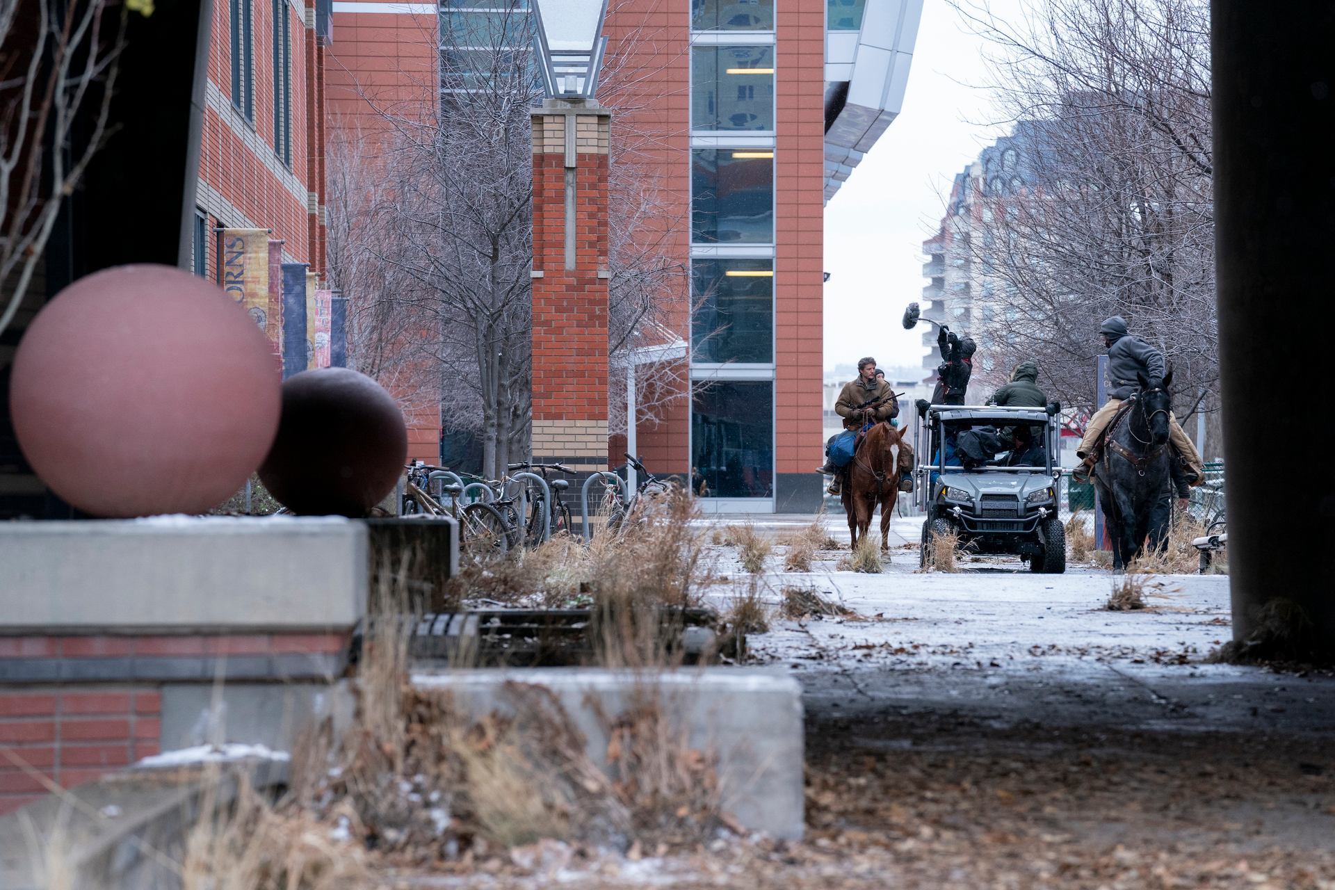 Pedro Pascal and Bella Ramsey on horseback shooting a scene at Calgary’s Southern Alberta Institute of Technology.