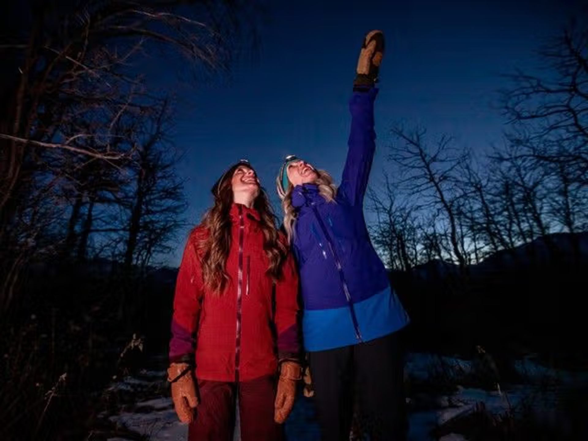 Two women looking up and pointing at the night sky
