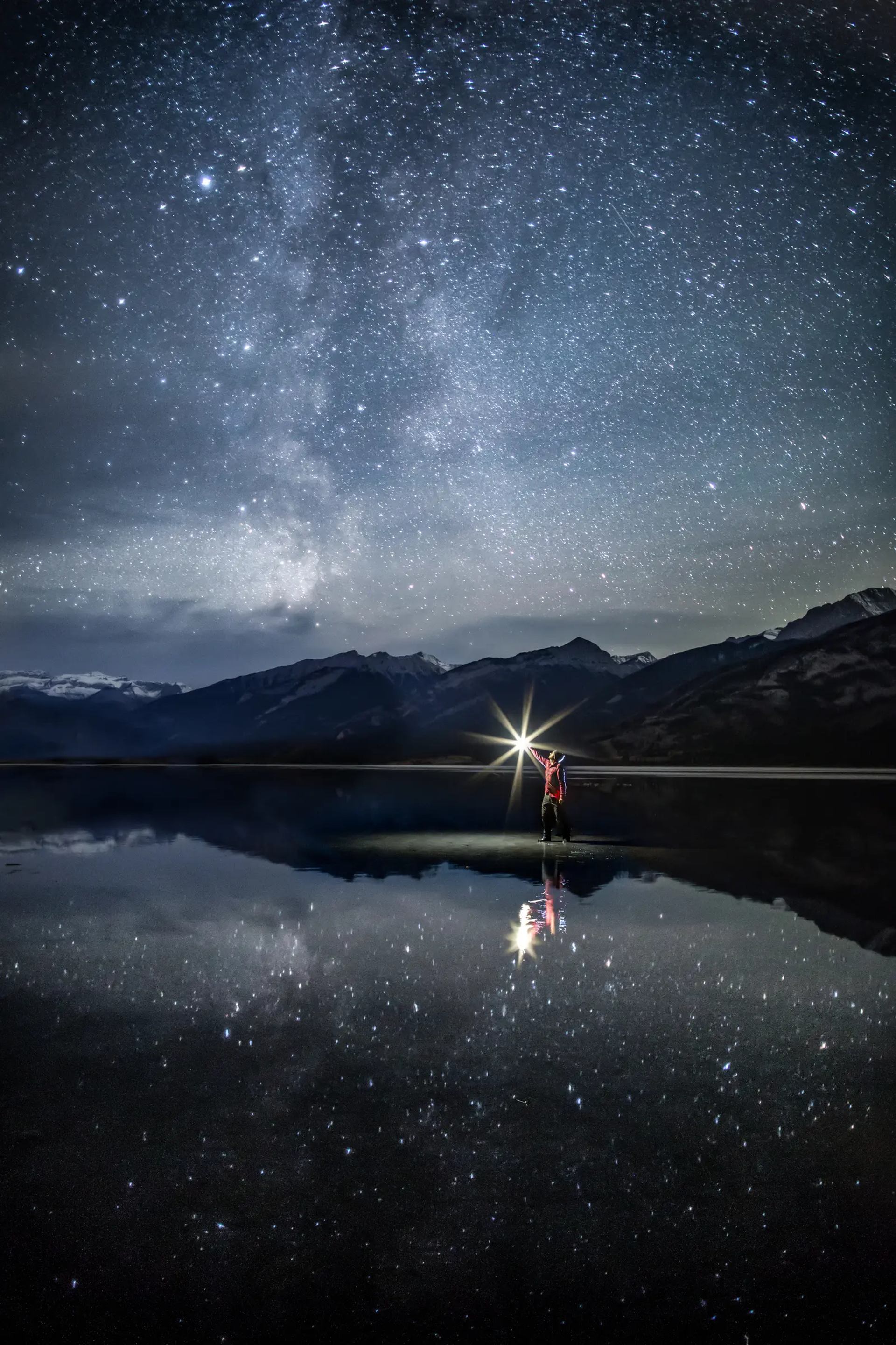 Man looking up at starry skies over Jasper Lake