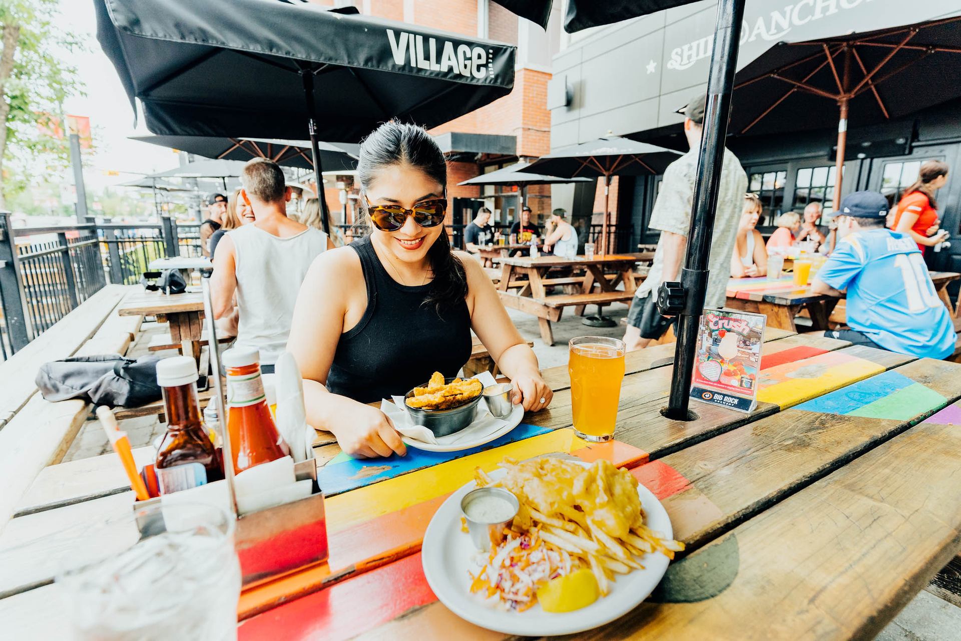 Woman at a picnic table on outdoor patio at the Ship and anchor pub calgary