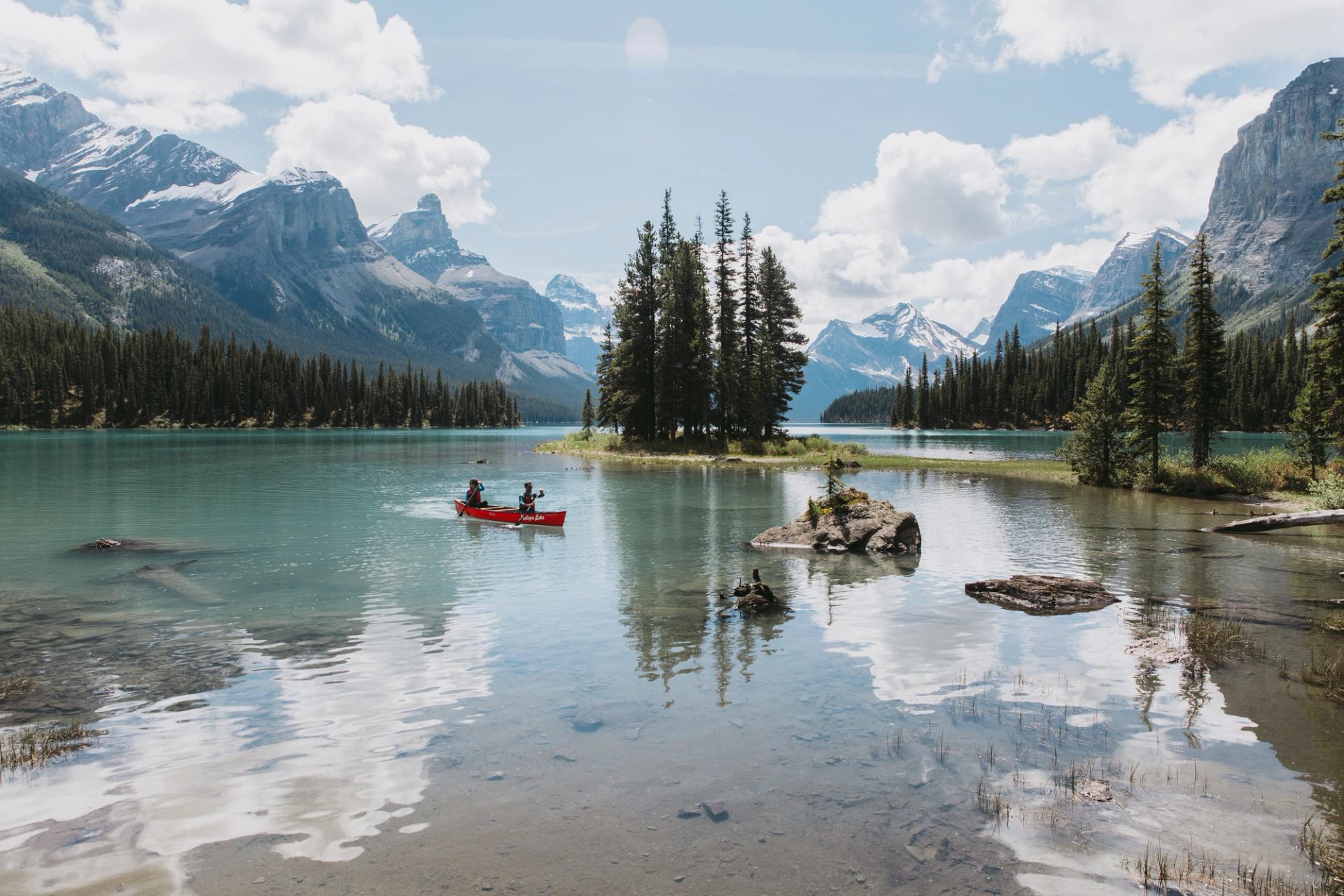 A peaceful canoeing scene in Jasper, with stunning mountain views reflecting on the calm water.
