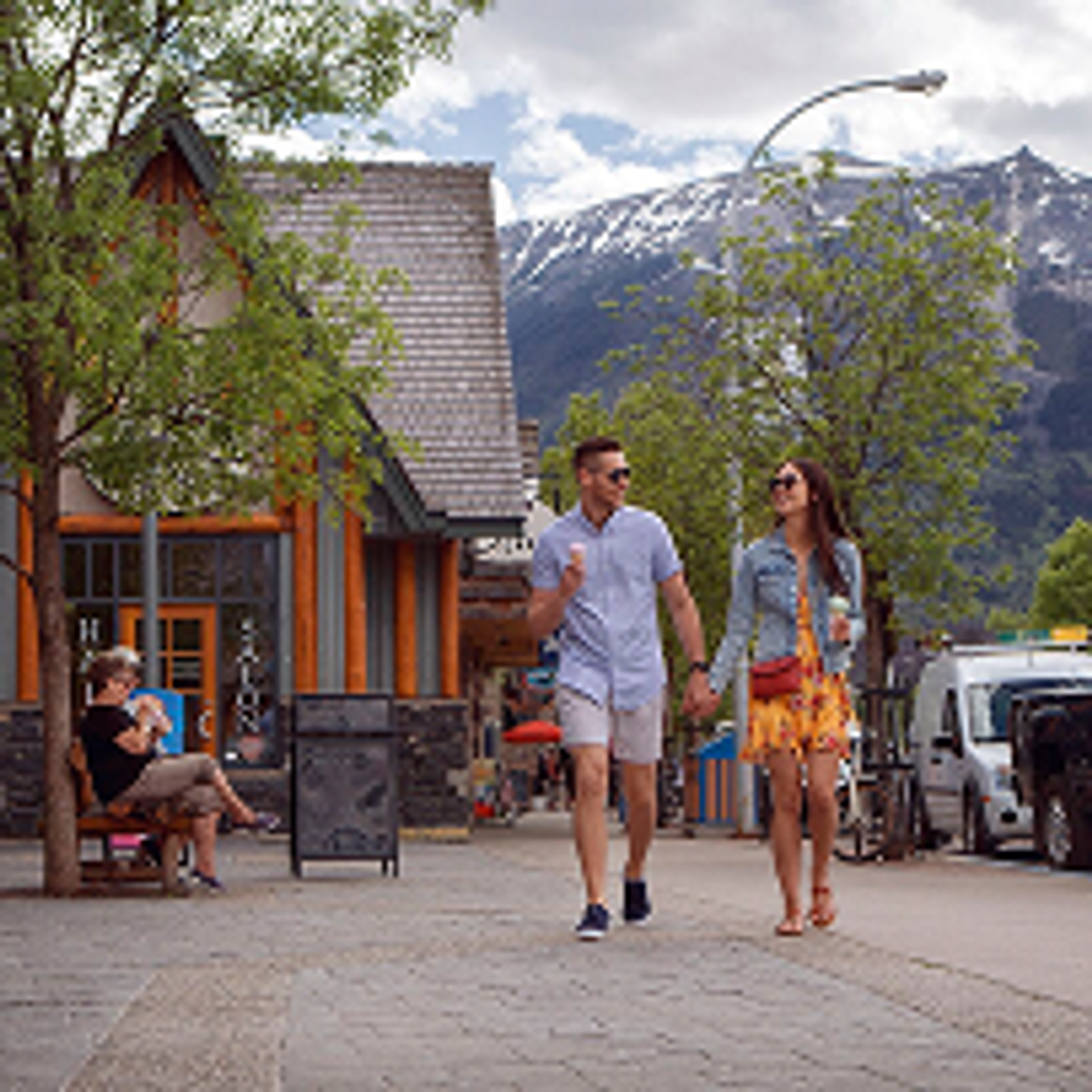 Couple strolling holding hands down a charming mountain town street.