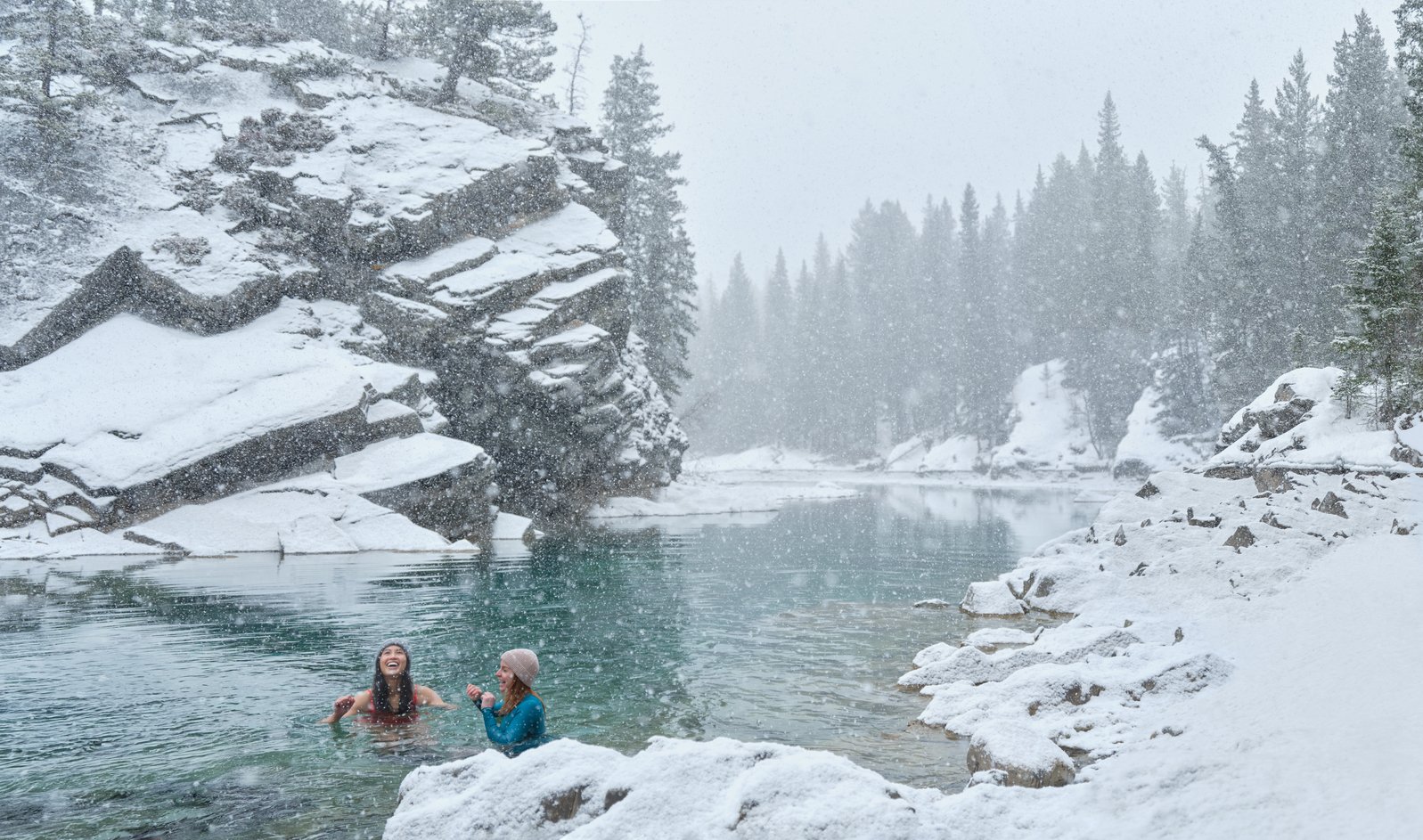 Two people cold plunging in an icy river.
