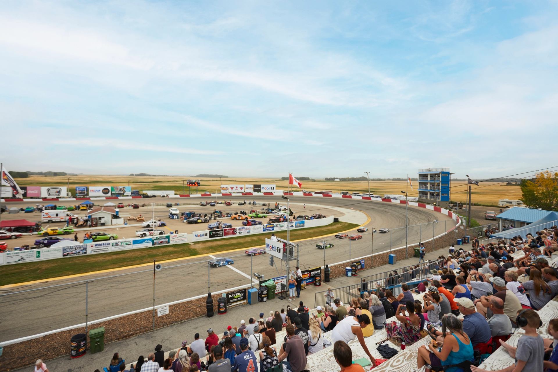 An audience watches race cars drive around the track at the Edmonton International Raceway.