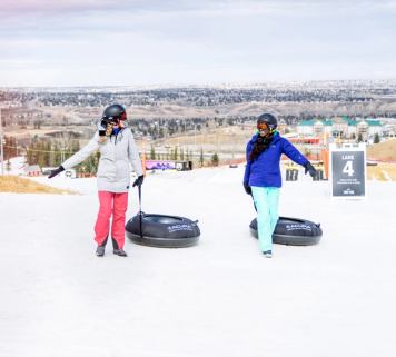 Friends pulling their tubes at the Tube Park at WinSport in Calgary