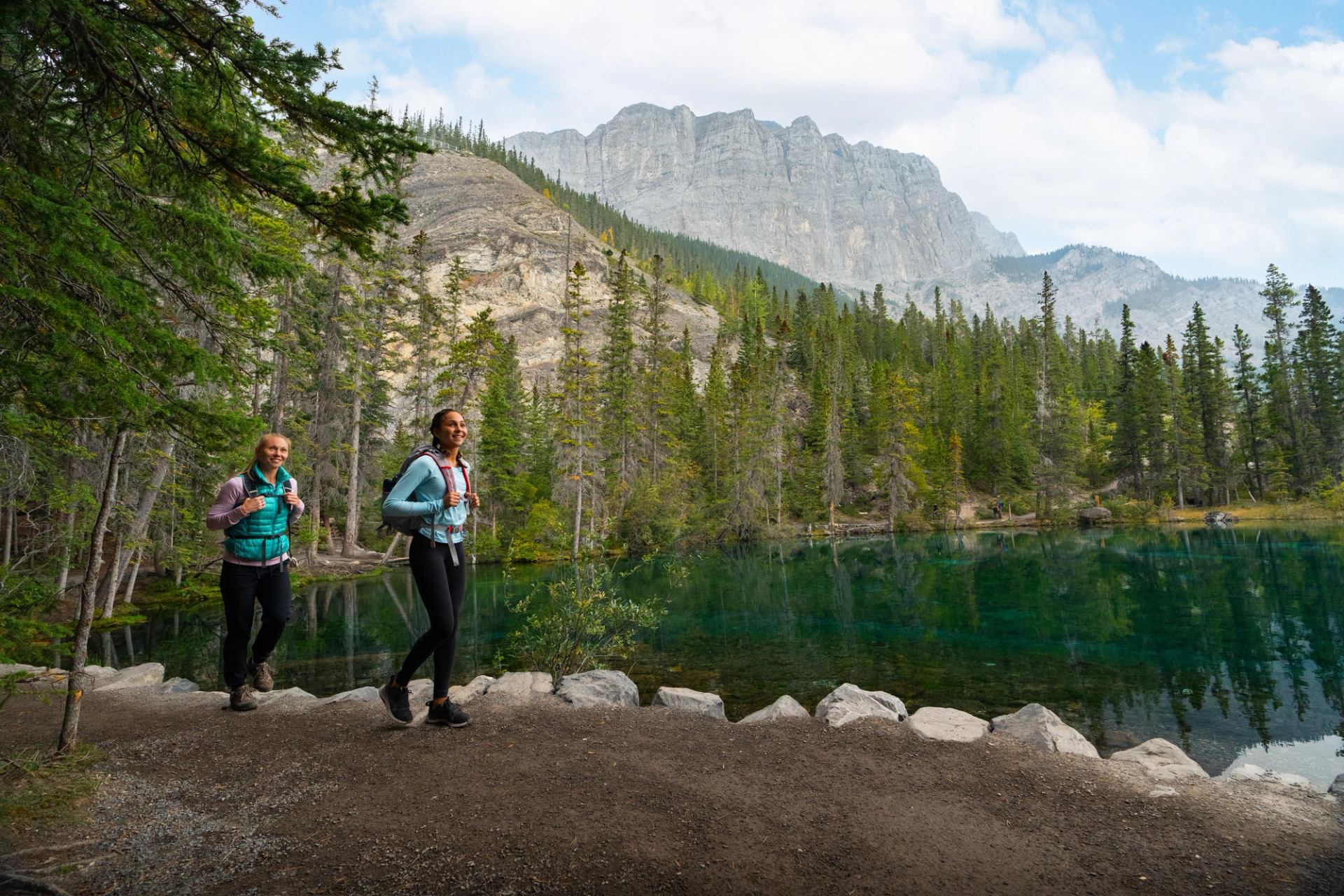A mother and daughter walk past Grassi Lakes as they take in the beautiful mountain views that surround them
