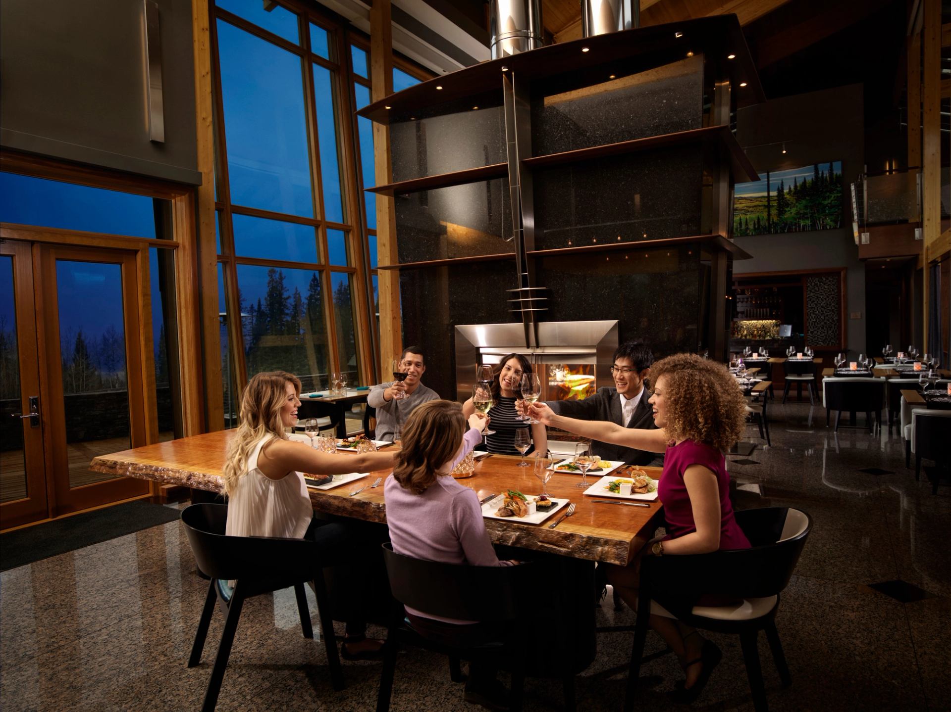 A group of friends saluting their beverages and enjoying dinner at the Azuridge Hotel.