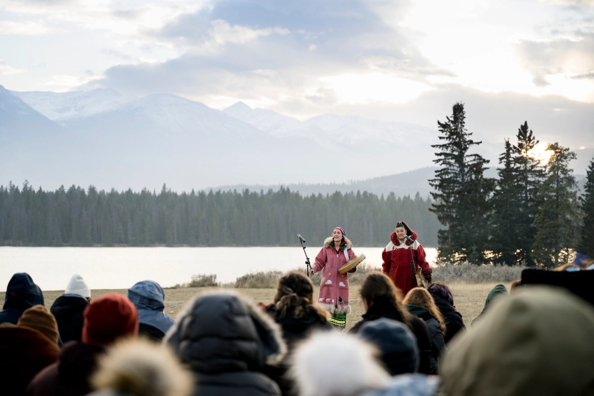 Wide shot of two indigenous women performers with audience