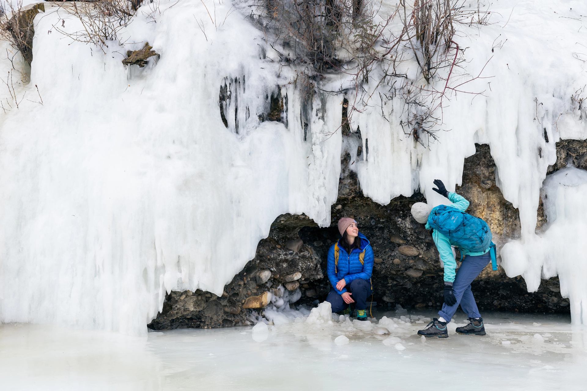 Two friends check out the frozen ice formations on a walk at Fish Creek Park in Calgary.