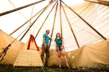 Couple inside tipi at River Ranche Lodge