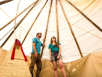 Couple inside tipi at River Ranche Lodge