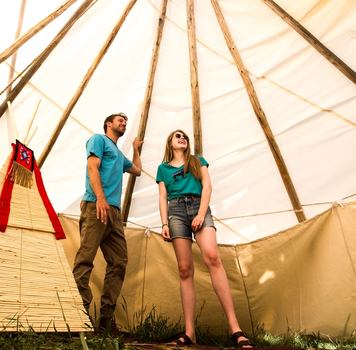 Couple inside tipi at River Ranche Lodge