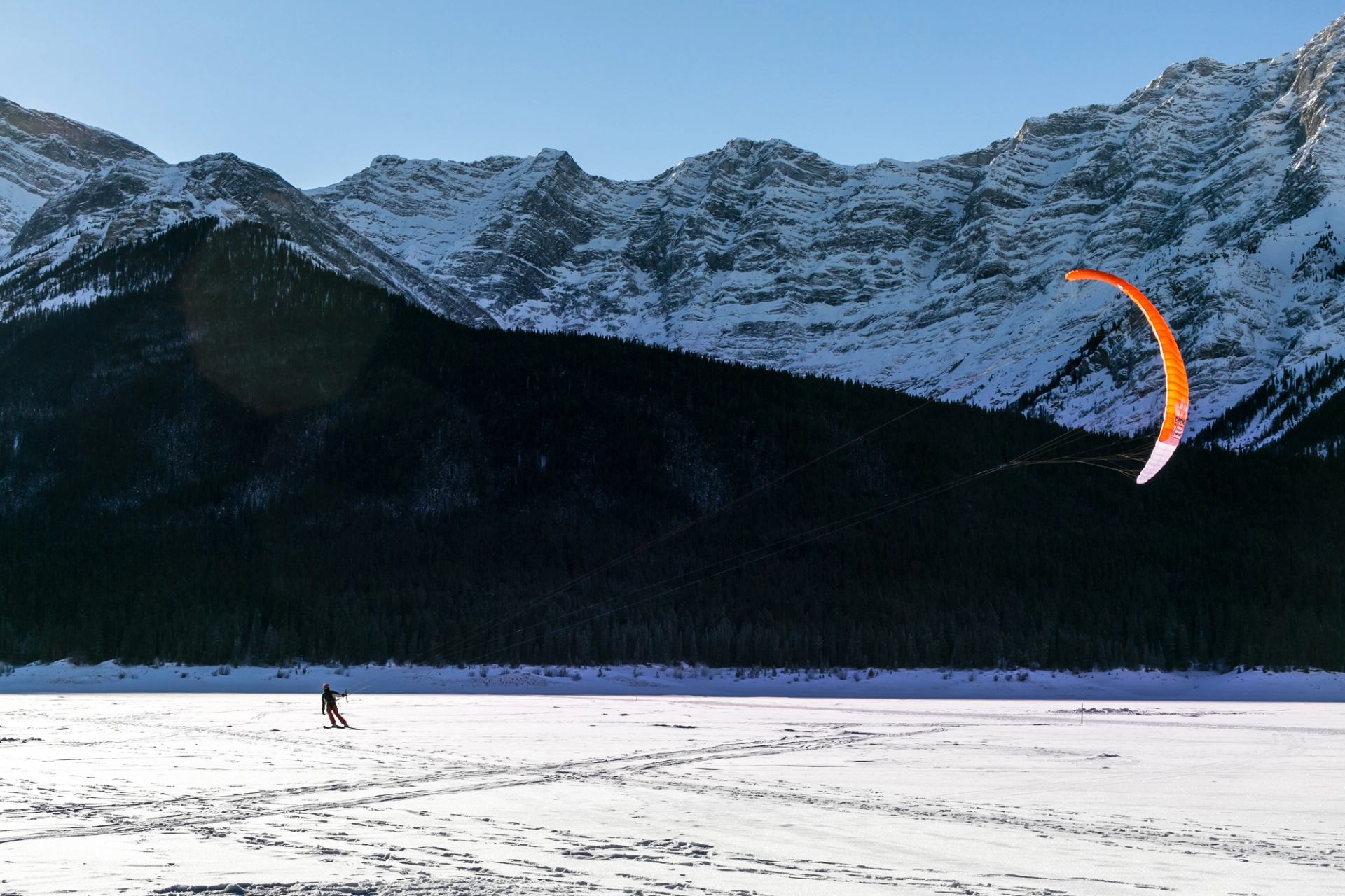 Person kite skiing/surfing on a lake near Canmore