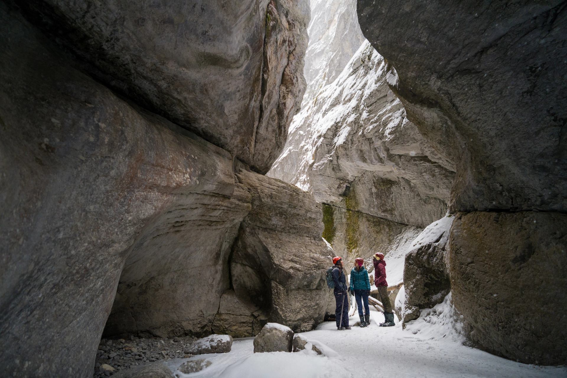 Guests and a guide walking through the canyon looking up at the canyon walls.