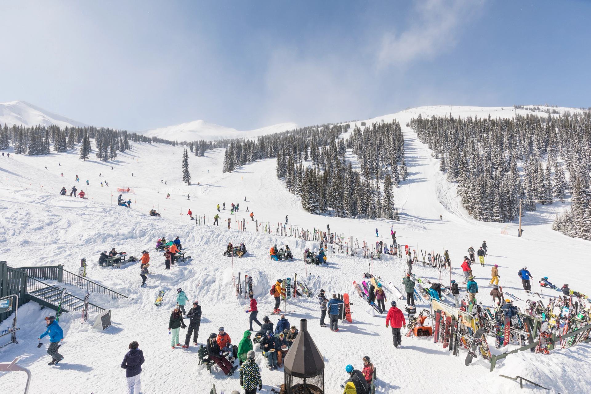 A skier skiing in powder underneath a chairlift while skiing at Marmot Basin in Jasper.