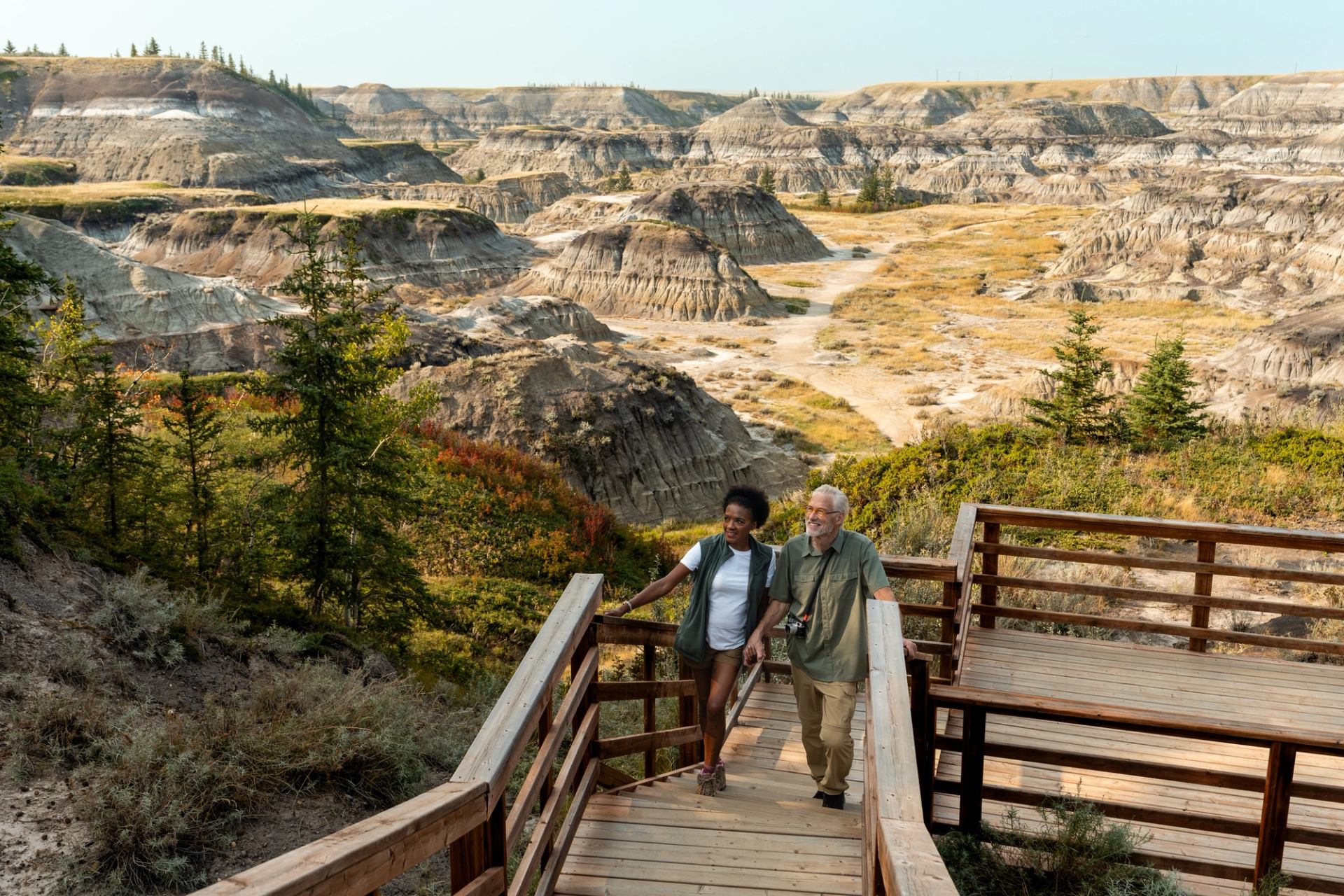 A couple walk up a wooden walkway at picturesque Horseshoe Canyon near Drumheller.