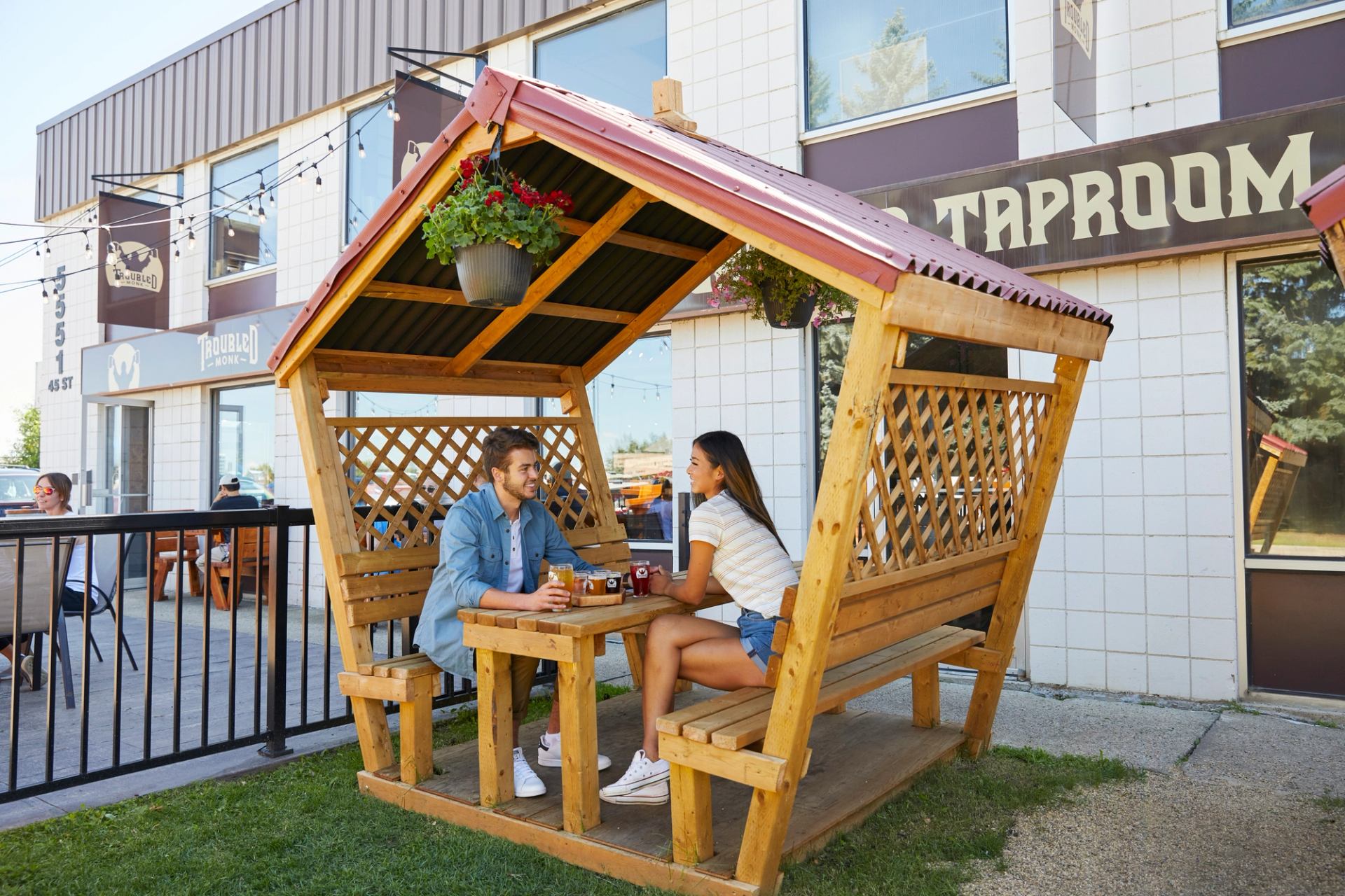 A man and woman sit at a picnic table drinking samples of beer outside Snake Lake Brewing Company.