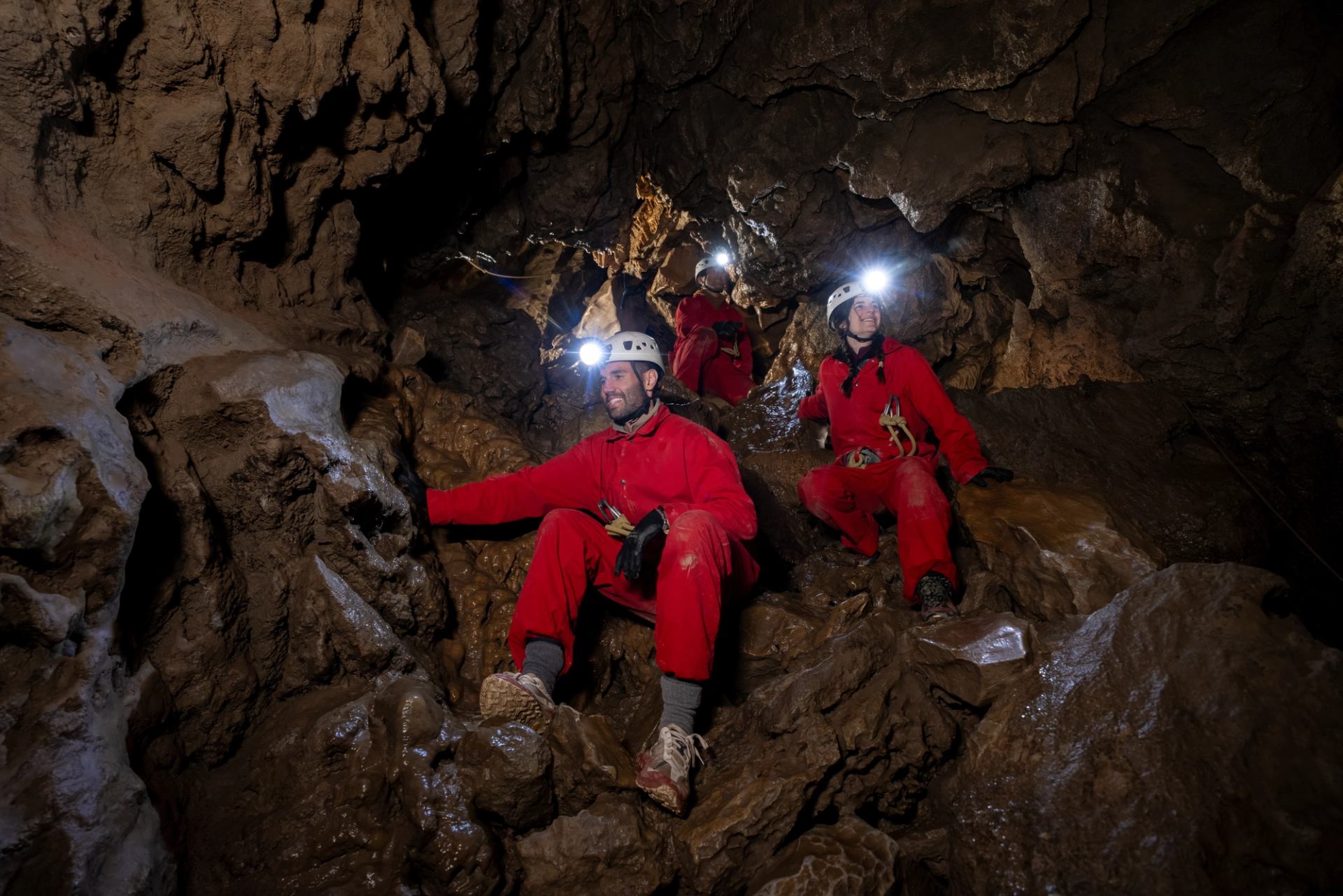 A tour group exploring Rat's Nest Cave with Canmore Cave Tours.