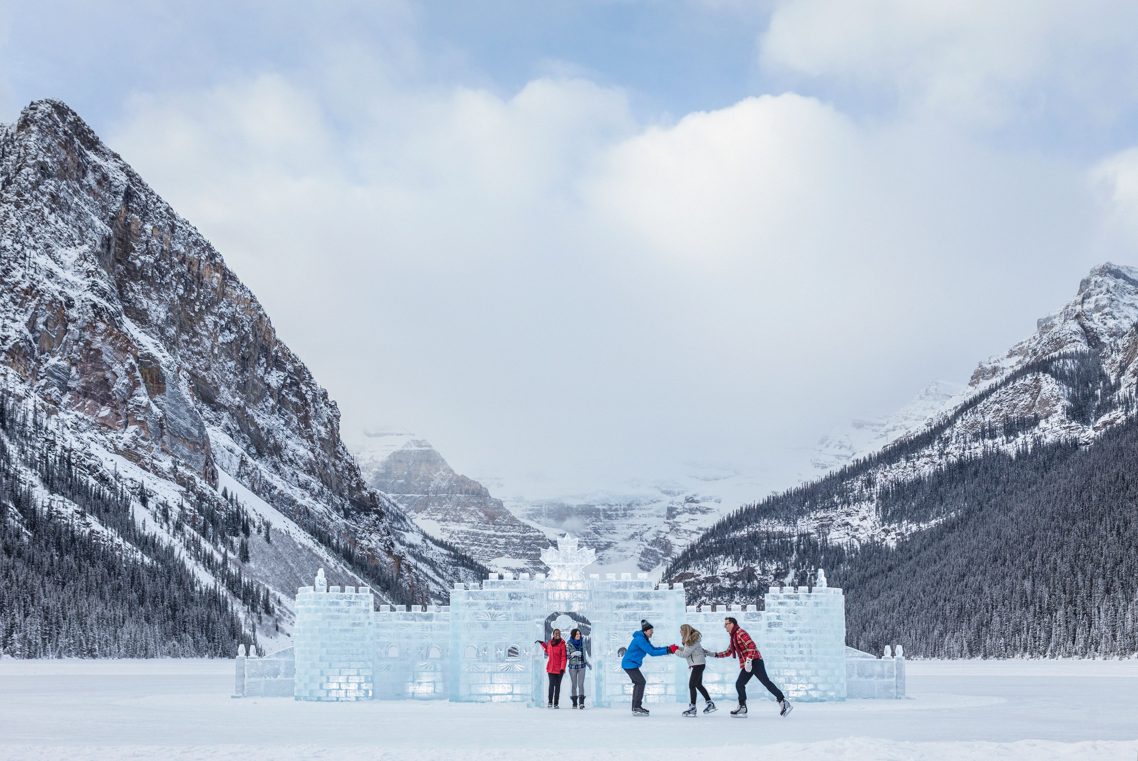 Group of people ice skating near the ice castle on Lake Louise in Banff National Park