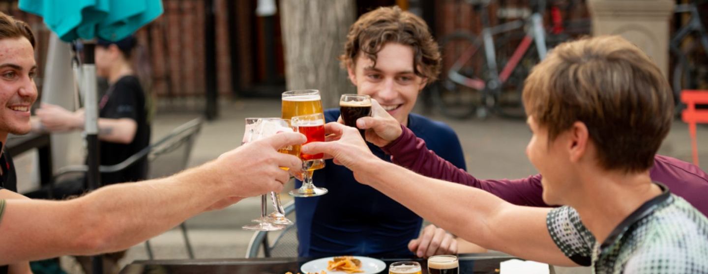 Group of friends raising glasses while having lunch on an outdoor patio.