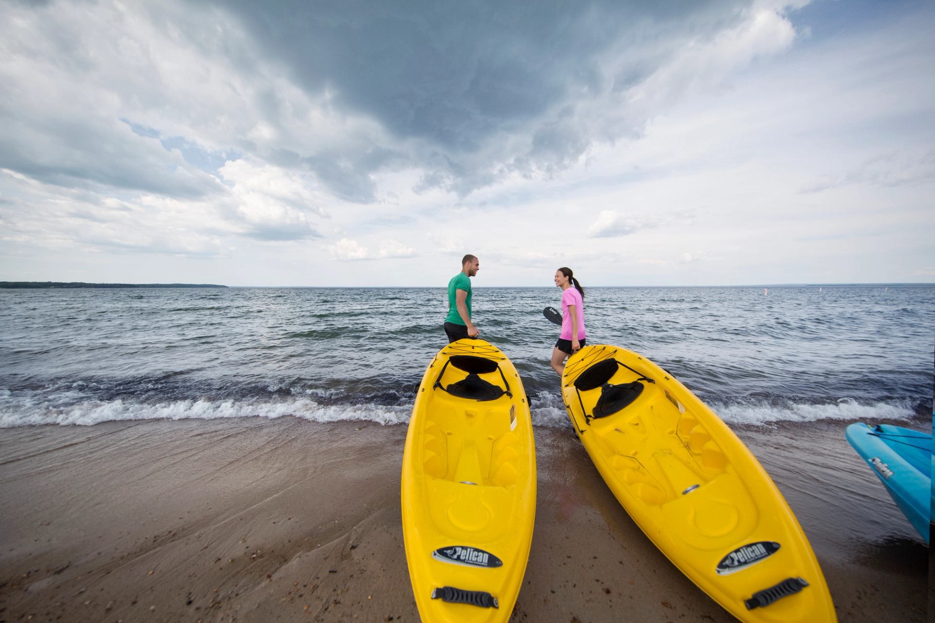 couple pull kayaks into cold lake provincial park