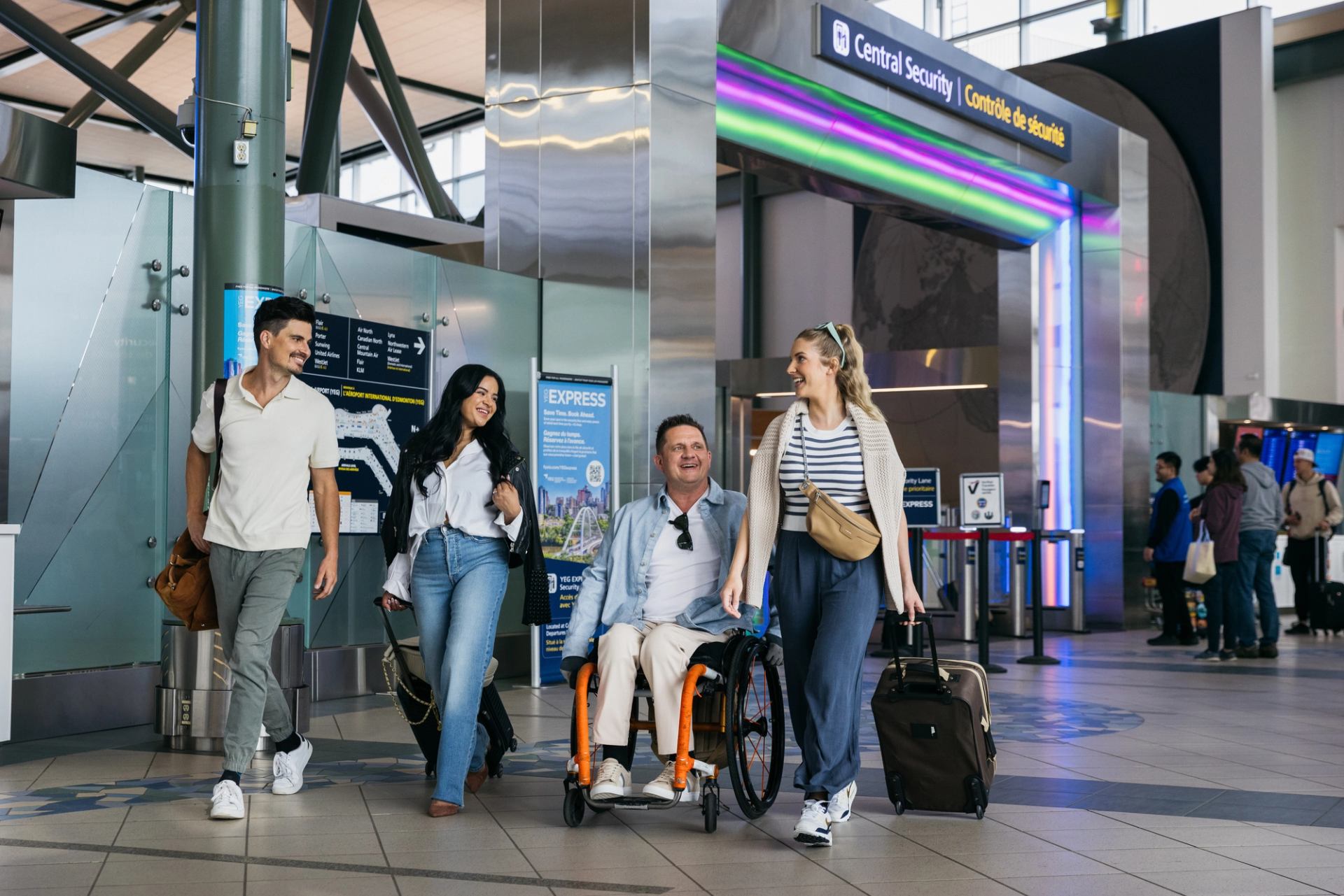 Four travellers walk past the main security gate at Edmonton's airport.