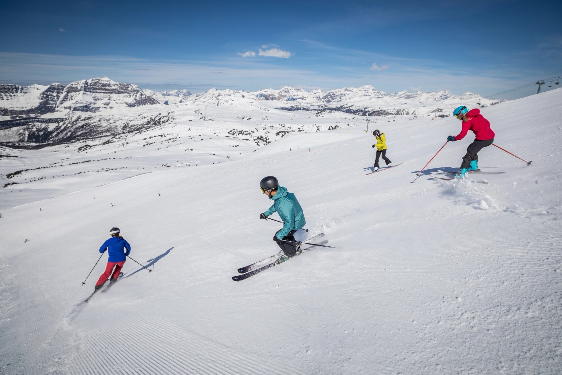 Skiers in bright jackets go spring Skiing at Sunshine Village